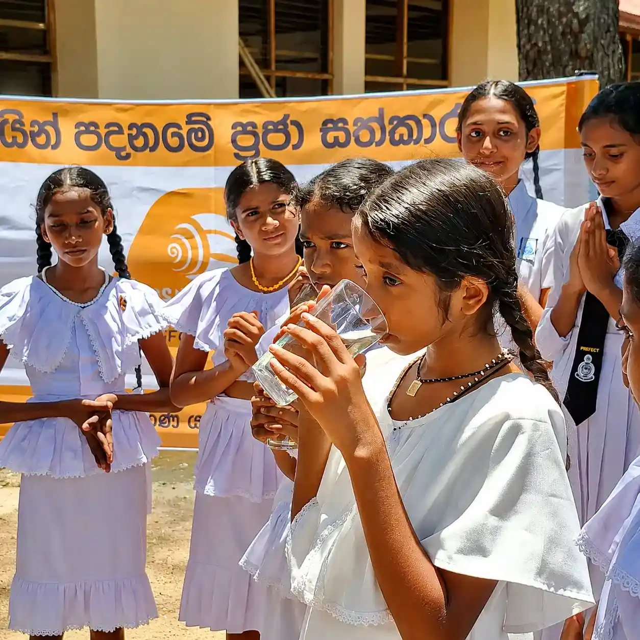 A child drinking water from a stainless steel cup