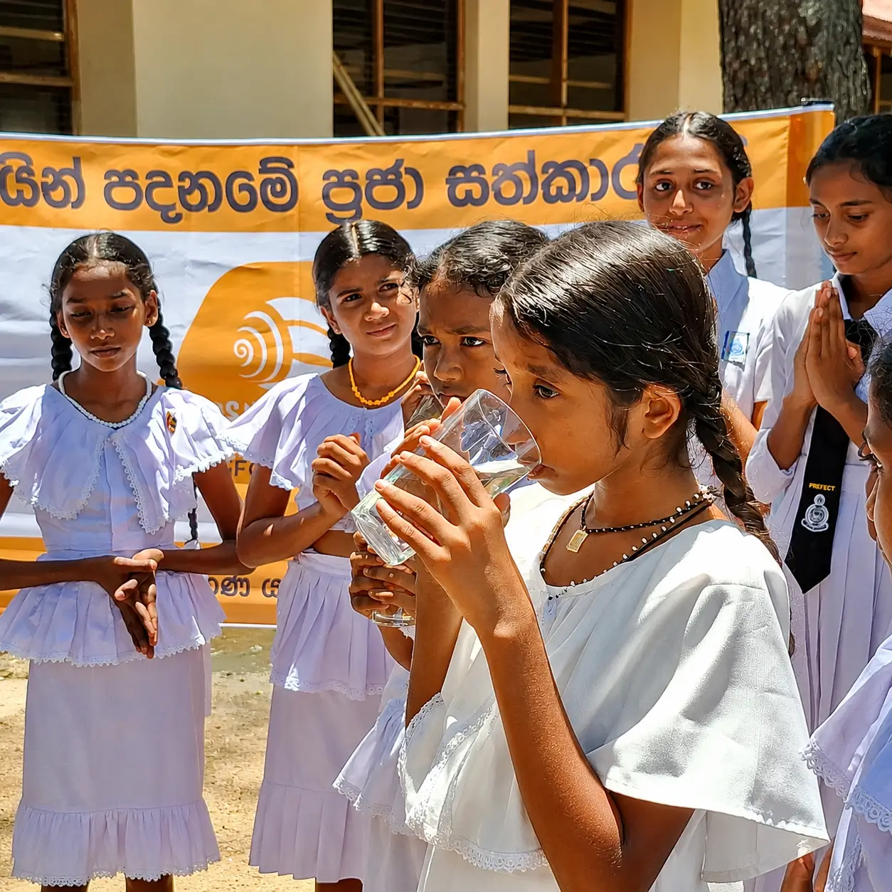 A child drinking water from a stainless steel cup
