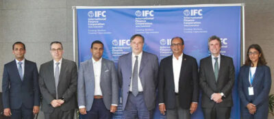 A diverse group of people in business attire, including suits and ties, standing together in a formal environment