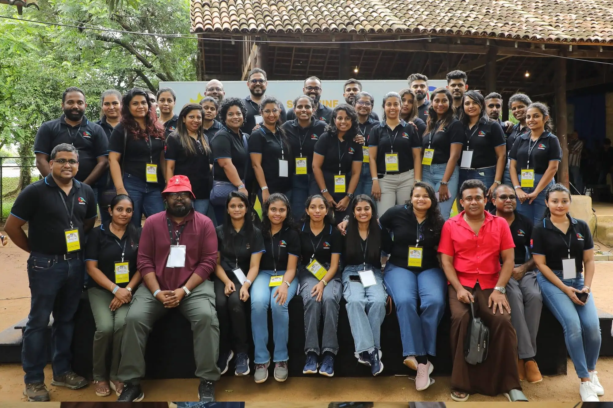 A group of people in black shirts and jeans smiling together during Sunshine Holdings’ Children’s Day celebrations