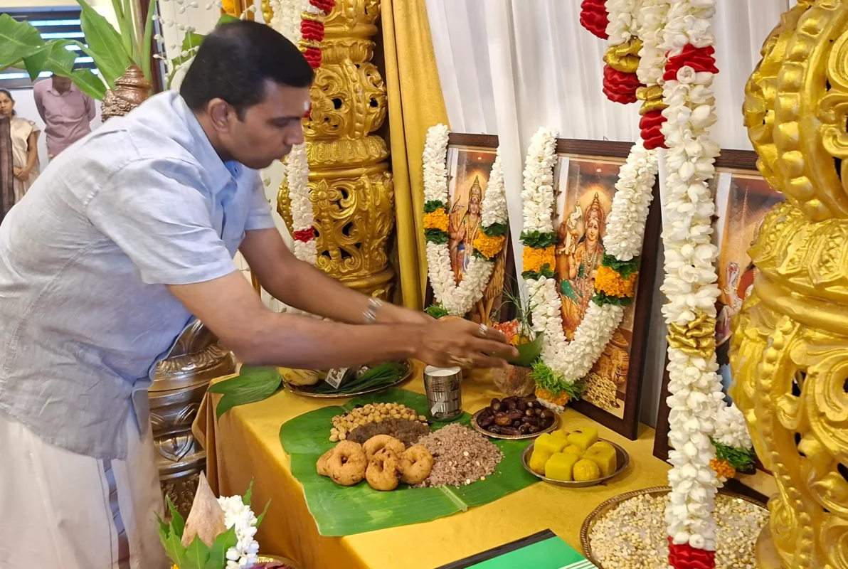 A person offering some foods and beetles to a photo of a god